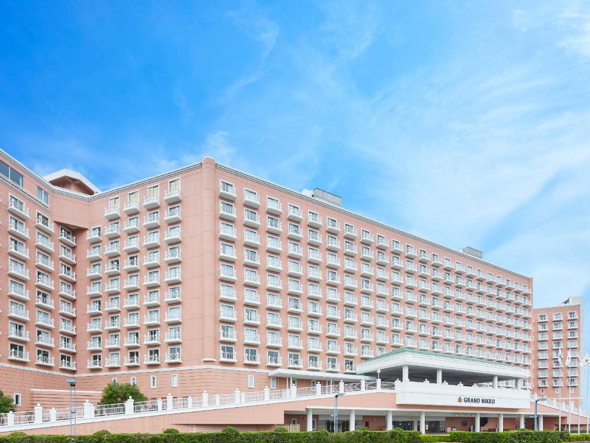 Hotel Grand Nikko Tokyo Bay Maihama Urayasu Exterior foto The photo depicts a large hotel building featuring a contemporary architectural design. The structure is predominantly pink, with multiple floors and numerous windows. There is a covered entrance at the front, and the setting appears to be well-maint