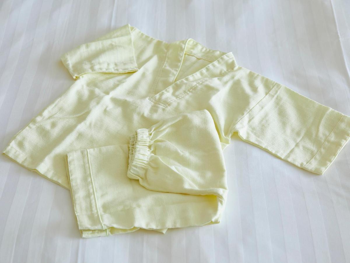 Hotel Grand Nikko Tokyo Bay Maihama Urayasu Exterior foto The photo shows a small, traditional outfit made of light yellow fabric. The outfit includes a short-sleeved top with a V-neck and a pair of matching pants. The design is simple, featuring a loose fit and a comfortable style, making it suitable for c