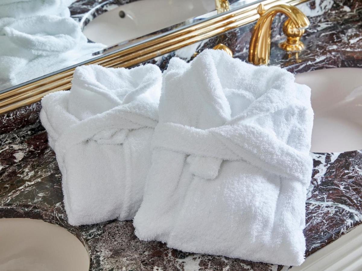 Hotel Grand Nikko Tokyo Bay Maihama Urayasu Exterior foto The photo shows two white bathrobes neatly folded and placed on a marble surface, likely in a luxurious bathroom setting. The bathrobes have a simple, classic design with belts tied around them. In the background, there appears to be a decorative mir