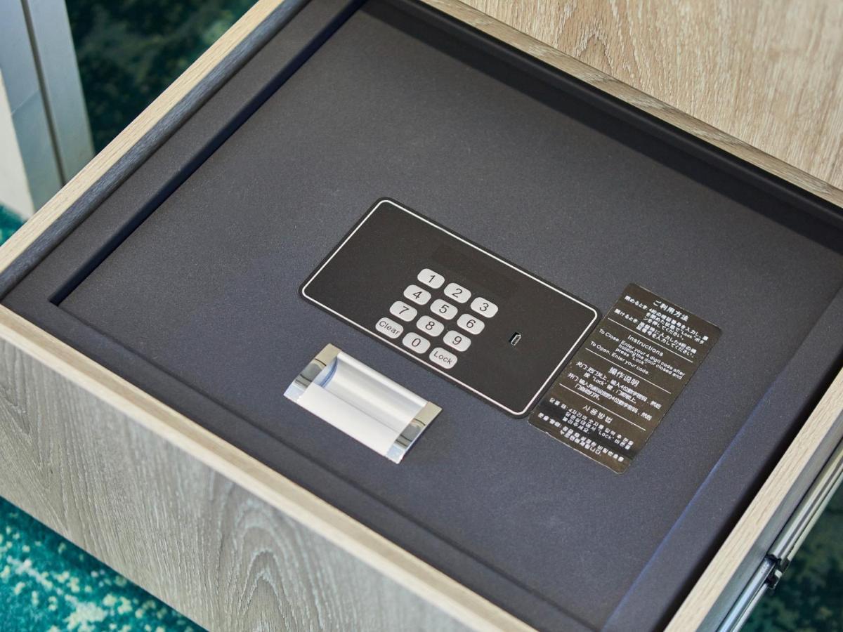 Hotel Grand Nikko Tokyo Bay Maihama Urayasu Exterior foto The photo shows a small safe that is installed in a drawer. Inside the safe, there is a digital keypad with numeric buttons for entering a code. Next to the keypad, there appears to be a small manual or instruction card. The interior of the safe is l