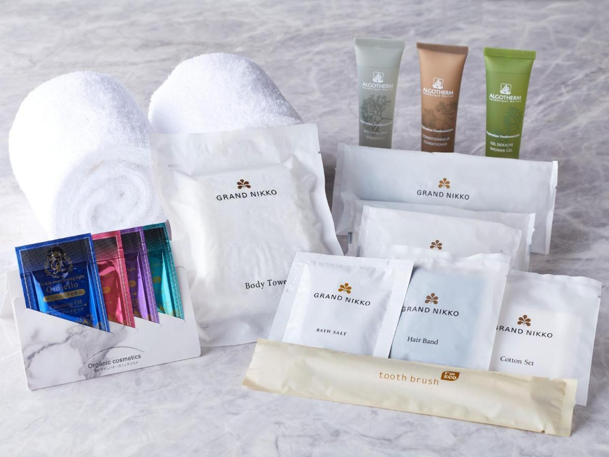 Hotel Grand Nikko Tokyo Bay Maihama Urayasu Exterior foto The photo displays a collection of spa or hotel toiletries. It includes:

- Two fluffy white towels.
- Multiple packages labeled "GRAND NAKO," which appear to be spa or body care products.
- Several small tubes of hair and body care items in green an