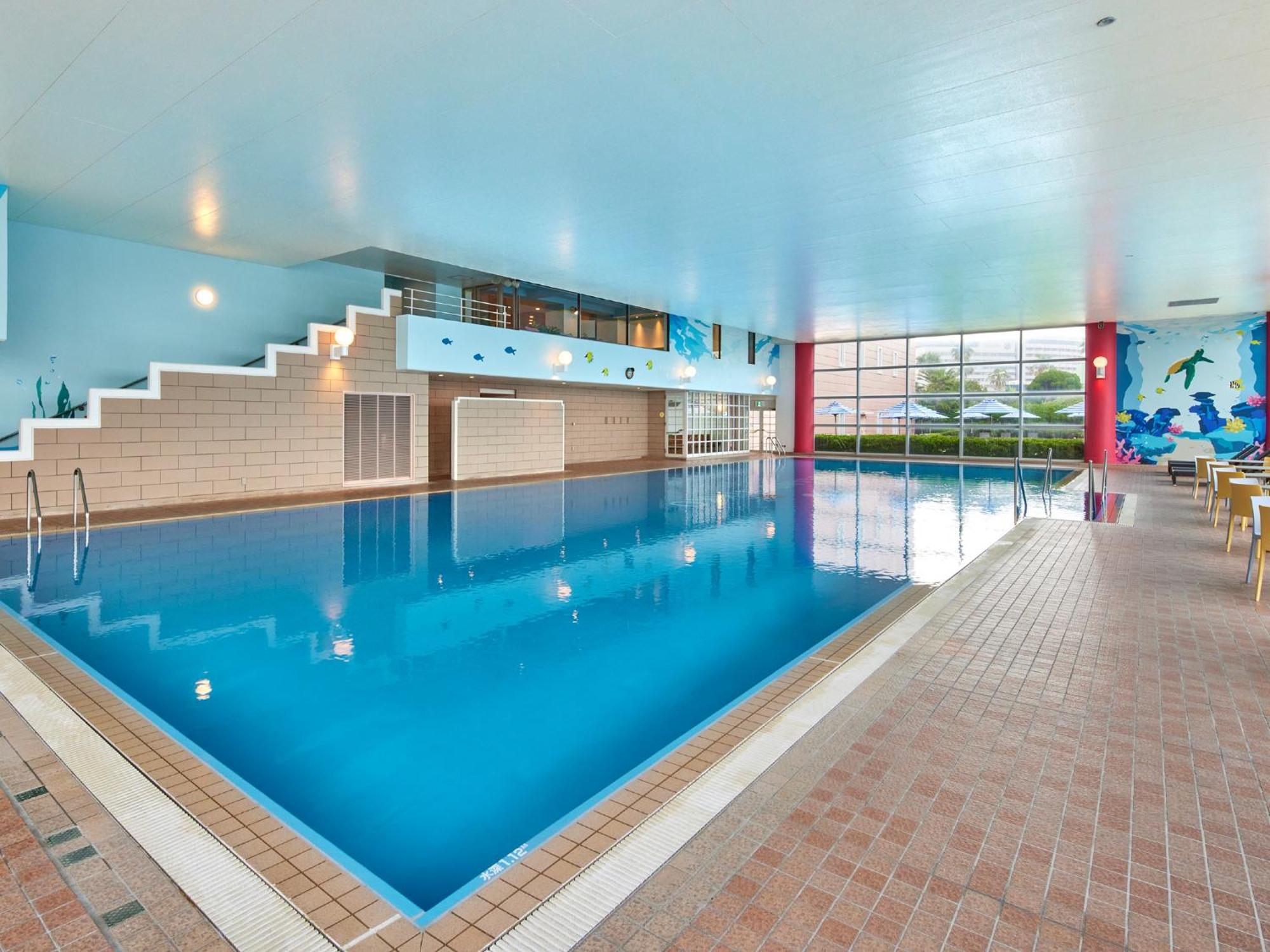 Hotel Grand Nikko Tokyo Bay Maihama Urayasu Exterior foto The photo shows an indoor swimming pool area with a spacious design. The pool has a clear blue water surface and is surrounded by a tiled deck. On one side of the pool, there are steps leading into the water, and there are large windows letting in na